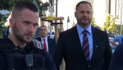 Screenshot Video Oleg Musyka - Ein Mitarbeiter der ukrainischen Präsidialadministration kommt auf Musyka zu, um dessen Brief in Empfang zu nehmen. Ein Berliner Polizist hindert Musyka daran, näher an Präsident Selenski heranzukommen.